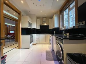 kuchnia z białymi szafkami, pralką i suszarką w obiekcie Luxe - Hyde Park - 2Bed 3Bath A/C + Lift w Londynie