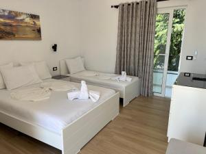2 camas en una habitación con ventana en Hotel Real, en Sarandë