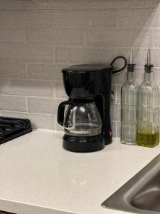 a coffee maker on a counter next to two glass bottles at 1 Bdr Apt in Irvine - Near John Wayne in Irvine