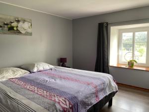 een slaapkamer met een bed en een raam bij Aux Trois Gîtes in La Chapelle