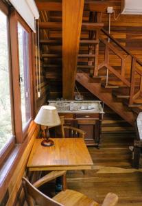 a wooden table with a lamp on it in a room with stairs at Parador Hampel in São Francisco de Paula