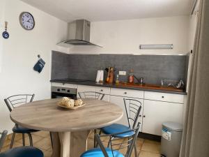 een keuken met een tafel en stoelen in een keuken bij Aux Trois Gîtes in La Chapelle