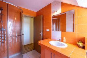 an orange bathroom with a sink and a shower at Sherpa's Hostel High Tatras in Štrbské Pleso +45 photos