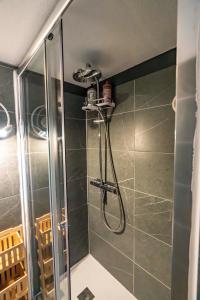 La salle de bains est pourvue d'une douche avec une porte en verre. dans l'établissement Villa Notre Dame : Vue sur port, 2min Grande plage, à Saint-Gilles-Croix-de-Vie
