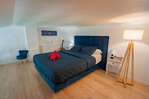 a bedroom with a blue bed with a red object on it at Villa Notre Dame : Vue sur port, 2min Grande plage in Saint-Gilles-Croix-de-Vie