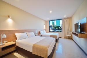 een hotelkamer met 2 bedden en een flatscreen-tv bij Chairu Eco Hotel in Santa Cruz de la Sierra