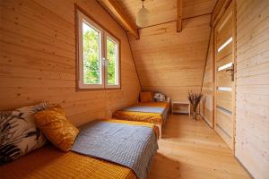 a room with three beds in a log cabin at Stilo Country Dargobądz in Wolin
