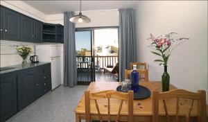 Una cocina con una mesa de madera con sillas y una cocina con vistas. en casa la vida loca 007, en Playa Calera