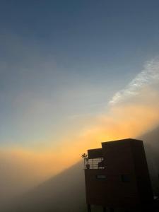 a silhouette of a building with the sunset in the background at Away Cabanas Pedra Azul 5 min Rota Lagarto, deck panorâmico in Domingos Martins +29 photos