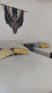 Una cama blanca con almohadas amarillas encima. en Illes medes, en L'Estartit