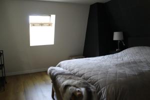 een slaapkamer met een wit bed en een raam bij Huisje Wenum - Apeldoorn met jacuzzi in Wenum