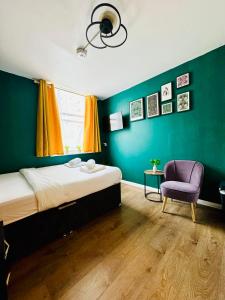 a bedroom with a bed and a purple chair at Private Studio Flat in City 1190 in London