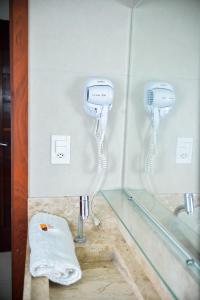 una habitación con dos teléfonos en la pared en hotel quatro coracoes, en Arapiraca