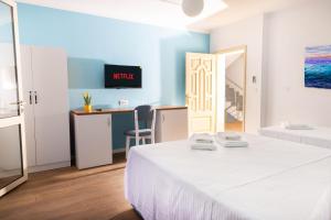 Schlafzimmer mit einem Bett und einem Schreibtisch mit einem TV in der Unterkunft Hotel Vila MAX in Durrës