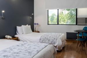 a hotel room with two beds and a window at Hotel Nippon y Centro de Eventos in Santiago