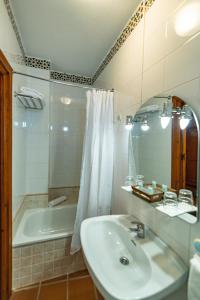 a bathroom with a sink and a bath tub at Hotel La Fragua I in Trevélez