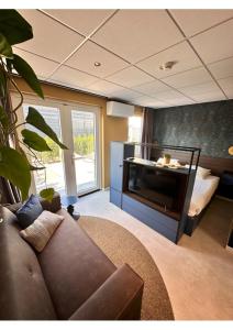 uma sala de estar com um sofá e uma televisão em Hotel Brasserie Smits em Wemeldinge