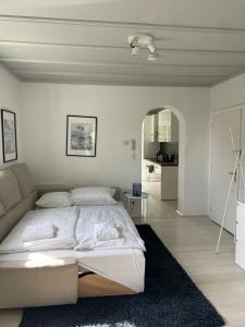 a white bedroom with a bed and a couch at Apartment in Velden am Wörthersee, Top 4 in Velden am Wörthersee