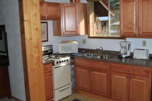 a kitchen with a white stove top oven next to a sink at Bear Paw Lodge in Vallecito