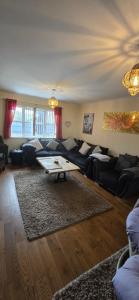 una sala de estar con un sofá y una mesa en Family home, en Johnston