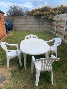 una mesa blanca y cuatro sillas en un patio en Ember, en Ballygerry