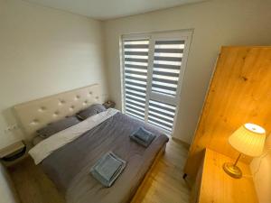 sypialnia z dużym łóżkiem i dużym oknem w obiekcie Duneville Apartments Mano Jūra 2 w Połądze