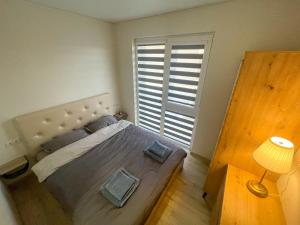 a bedroom with a large bed with a large window at Duneville Apartments Mano Jūra 2 in Palanga