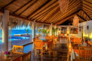 a dining room with a balcony overlooking the ocean at Yemaya Boutique Hotel en Canoas in Canoas de Punta Sal