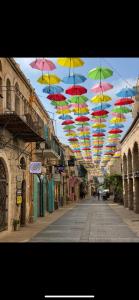 a row of colorful umbrellas hanging over a street at La Guta Studio Suite The Campari Suite in Jerusalem