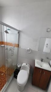 y baño con aseo, lavabo y ducha. en Hotel Torre del Viento cali, en Cali