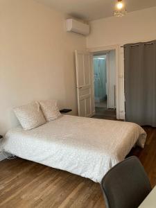 ein Schlafzimmer mit einem Bett und einem Stuhl in der Unterkunft Appartement Notre Dame in Montluçon