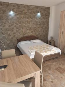 a bedroom with a bed and a table and chairs at Apartments Fillip in Petrovac na Moru