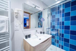 a bathroom with a sink and blue tiles at Suites Coronell d'En Vila in Perpignan