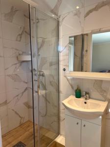een badkamer met een douche en een wastafel bij Pokoje Gościnne - Apartamenty MATI in Kopalino