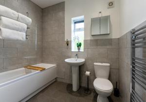 ein Badezimmer mit einem WC, einem Waschbecken und einer Badewanne in der Unterkunft Tettenhall Lodge Apartment in Wolverhampton