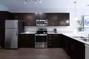 a kitchen with wooden cabinets and stainless steel appliances at Green Stone in Greenville