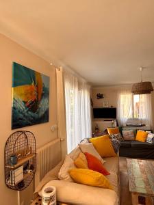 a living room with a couch with yellow pillows at Villa Retour de Plage in Anthéor