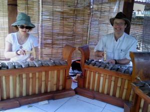 a man and a woman playing an electronic instrument at Dewa Put Guest House in Ubud