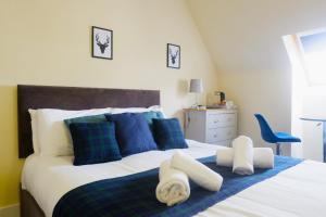 um quarto com uma cama grande e almofadas azuis em Jacobite house em Inverness
