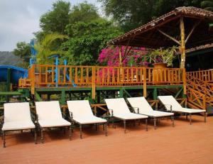 un grupo de sillas blancas y una terraza de madera en Posada Ecologica La Abuela en La Laguna