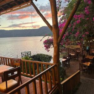 a patio with tables and chairs and a view of the water at Posada Ecologica La Abuela in La Laguna