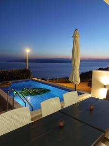 Villa con piscina y sombrilla en Charmy Apartments Petra with Pool, en Makarska