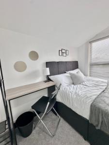 a bedroom with a bed and a desk with a chair at Gillingham 4 bed Guest House in Gillingham