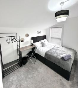 a bedroom with a bed and a desk in it at Gillingham 4 bed Guest House in Gillingham +8 photos