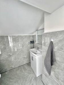 a white bathroom with a sink and a toilet at Gillingham 4 bed Guest House in Gillingham
