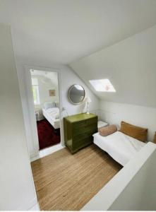 ein Schlafzimmer mit einer grünen Kommode und einem Spiegel in der Unterkunft Luna in Marstal