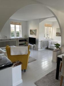 uma sala de estar com um arco e um sofá amarelo em Luna em Marstal
