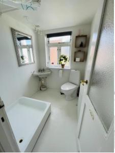 a white bathroom with a toilet and a sink at Luna in Marstal