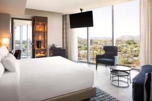 Caesars Republic Scottsdale في سكوتسديل: غرفة نوم بسرير ابيض ونافذة كبيرة