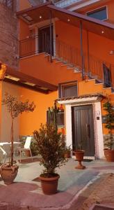 un bâtiment orange avec des plantes en pot devant lui dans l'établissement Casa Francesca, à Mercato San Severino